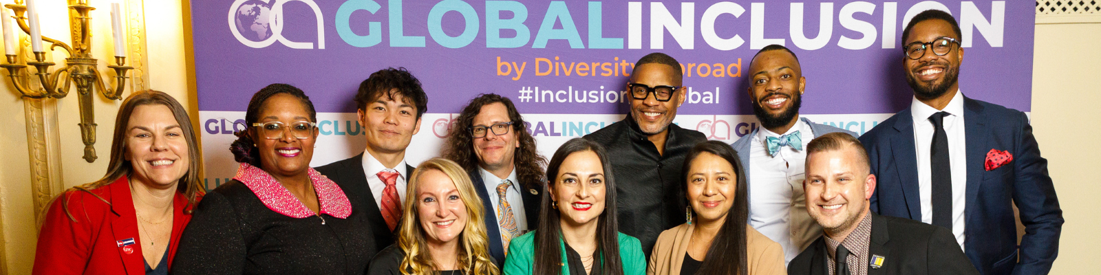 Excellence in Diversity and Inclusion in International Education Awardee recipients. 11 people smiling in front of a step and repeat banner